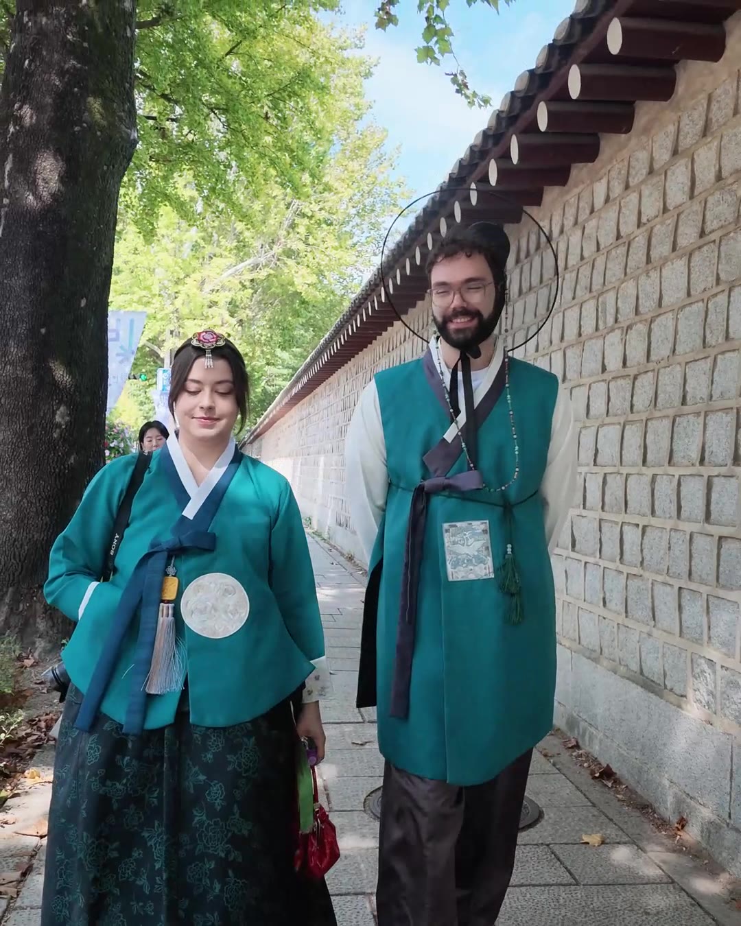 Guests in hanbok walking along the Gyeongbokgung Palace wall